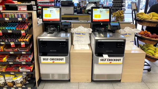 A photo of self checkout kiosks inside a convenience store. Each machine says "self checkout."