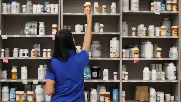 A pharmacy technician grabs a bottle of drugs off a shelve at the central pharmacy of Intermountain Heathcare.