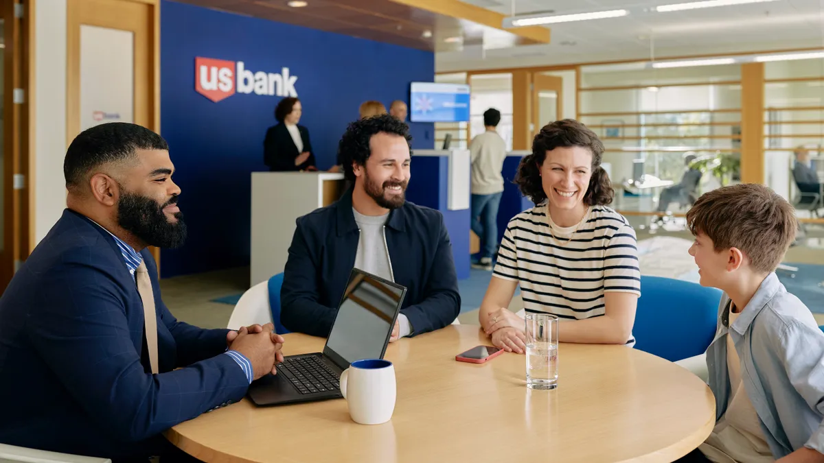 Four people sit at a table in a U.S. Bank location