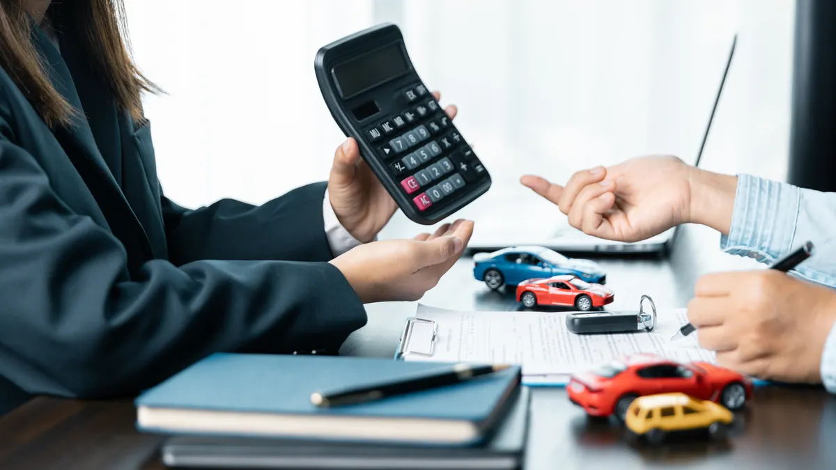 A sales manager explains the financial terms of purchasing a vehicle.