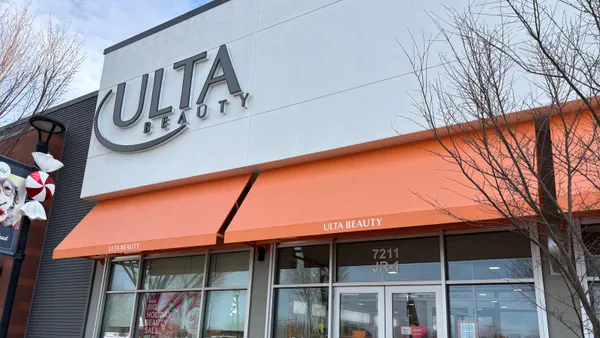 An orange and white Ulta Beauty storefront with a tree in front