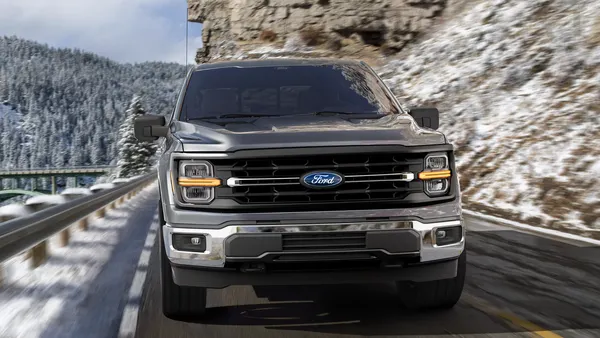 A media photo showing the front view of a 2025 Ford F-150 pickup traveling on a mountain road with snow on the ground