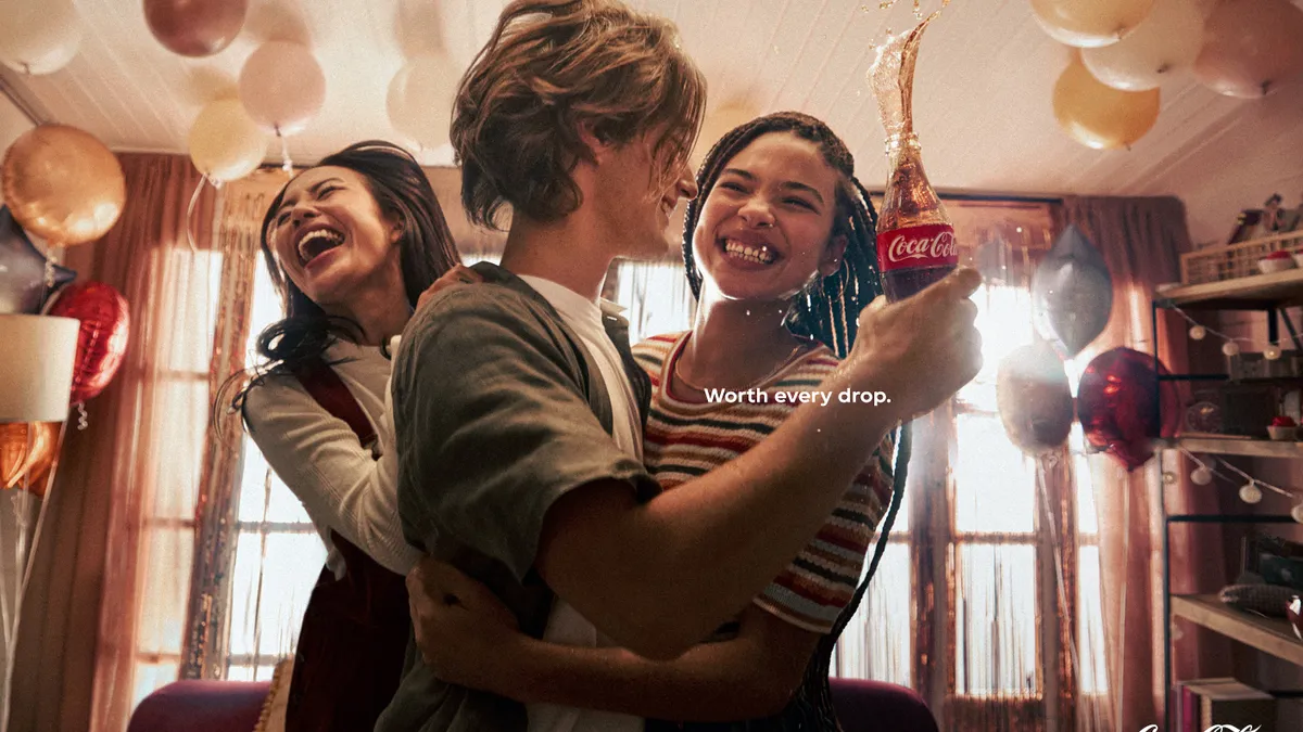 Three friends embrace in Coca-Cola's "Spill" campaign