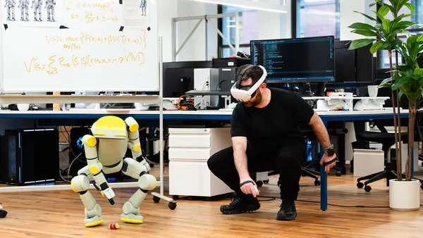 A Fauna Robotics employee trains its Sprout robot to pick up an object using a virtual reality headset.