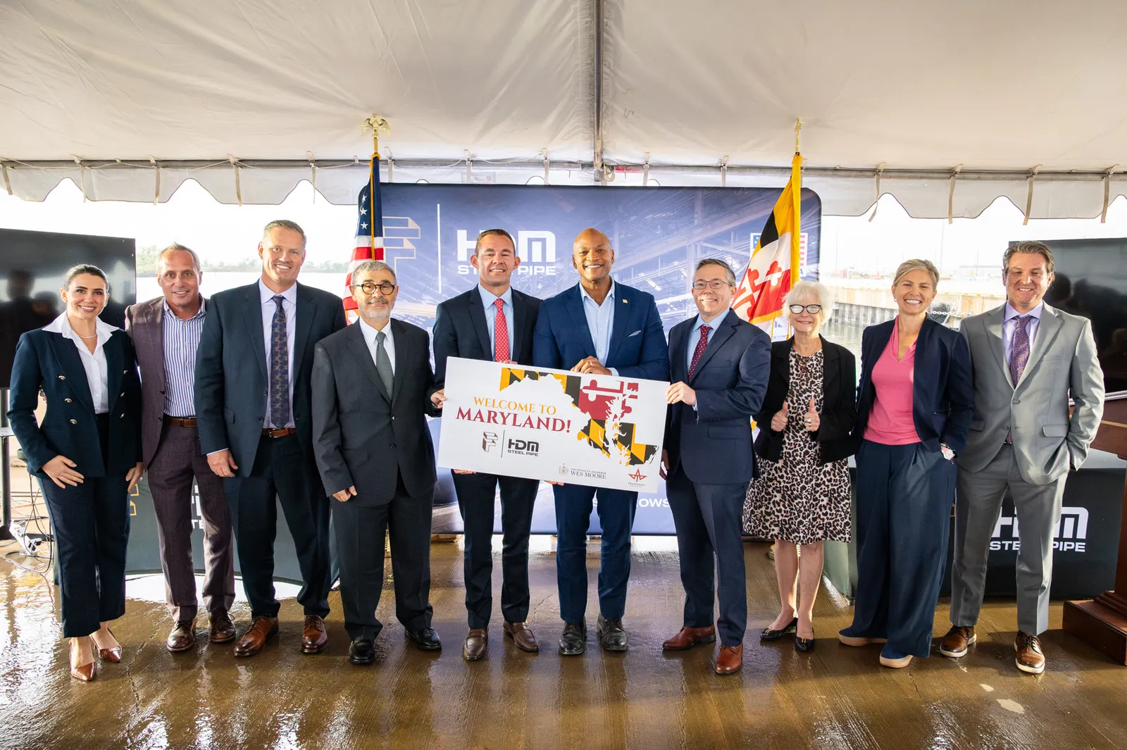 A group of people in suits hold a sign that says &quot;Maryland&quot; at a ceremonial event