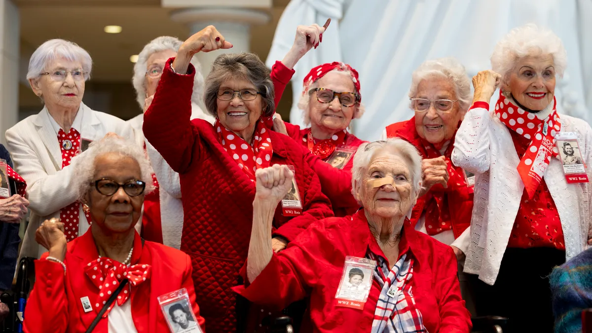 Elderly people wearing read and white attire and red and white polka dot scarves.