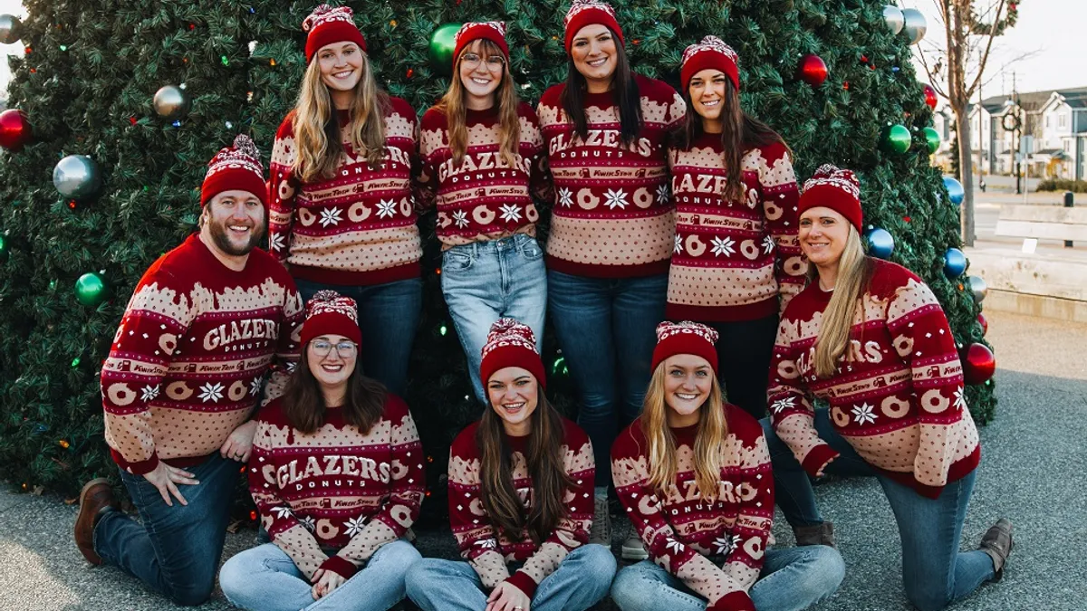 A photo of people wearing Kwik Trip ugly sweaters and beanie hats.