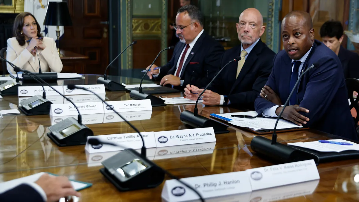 People sit around a table with microphones and name tags in front of them.