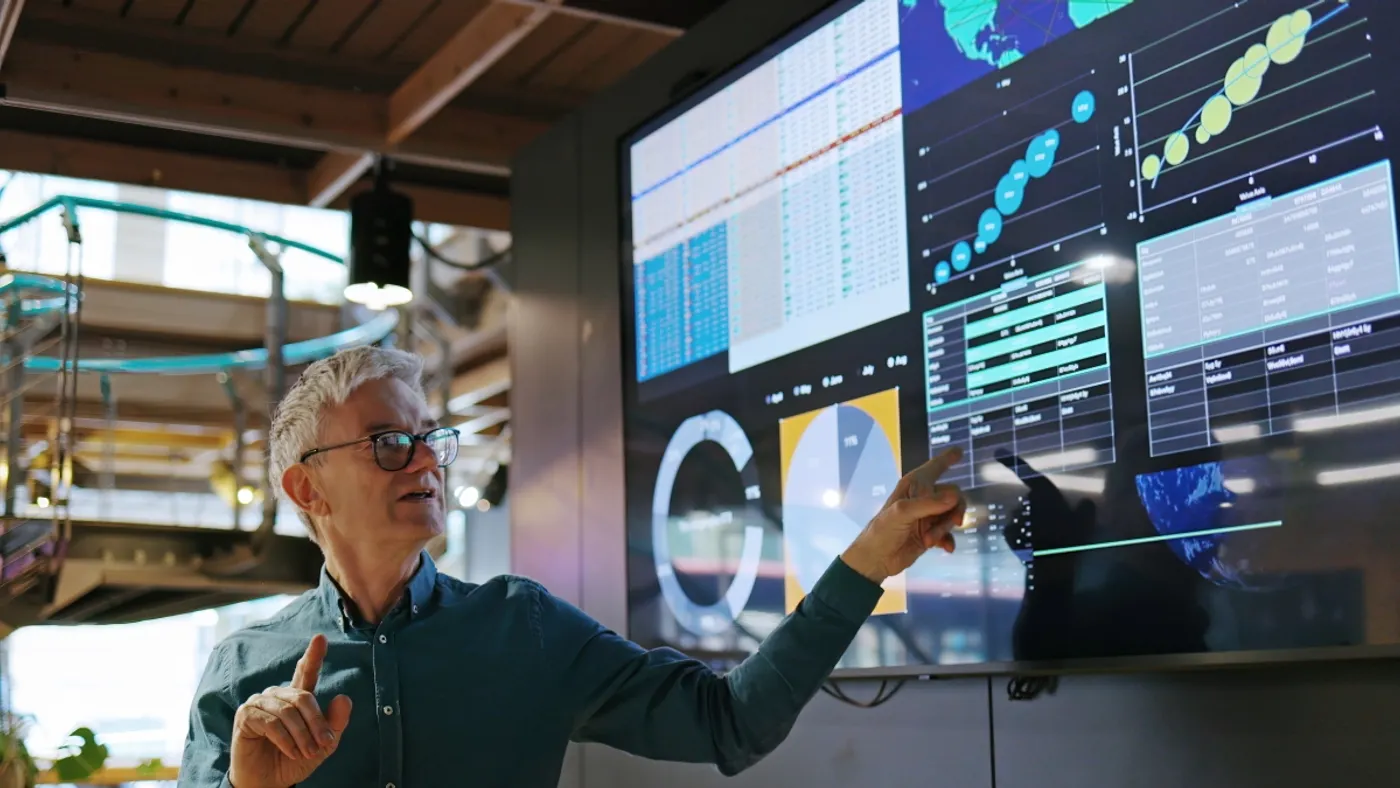 Business professional pointing at dashboard