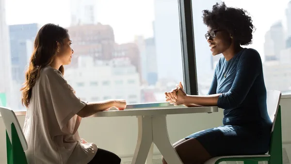 2 Women sitting across from each other at a table