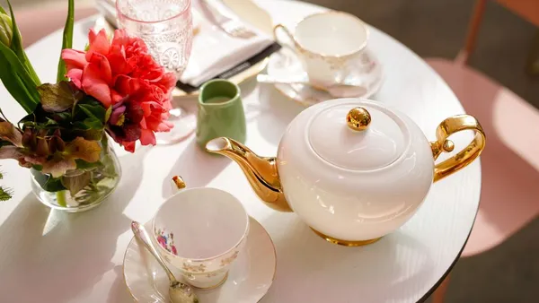 A table with a teapot and tea during high tea service.