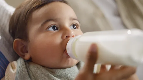baby being fed formula in a bottle