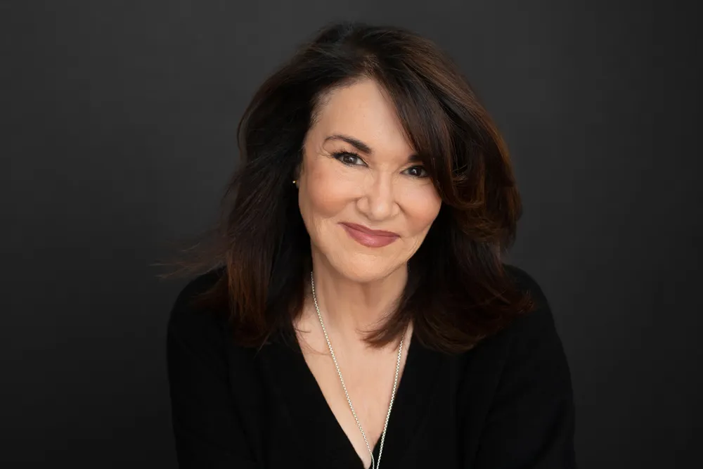 A person&#x27;s headshot against a dark backdrop