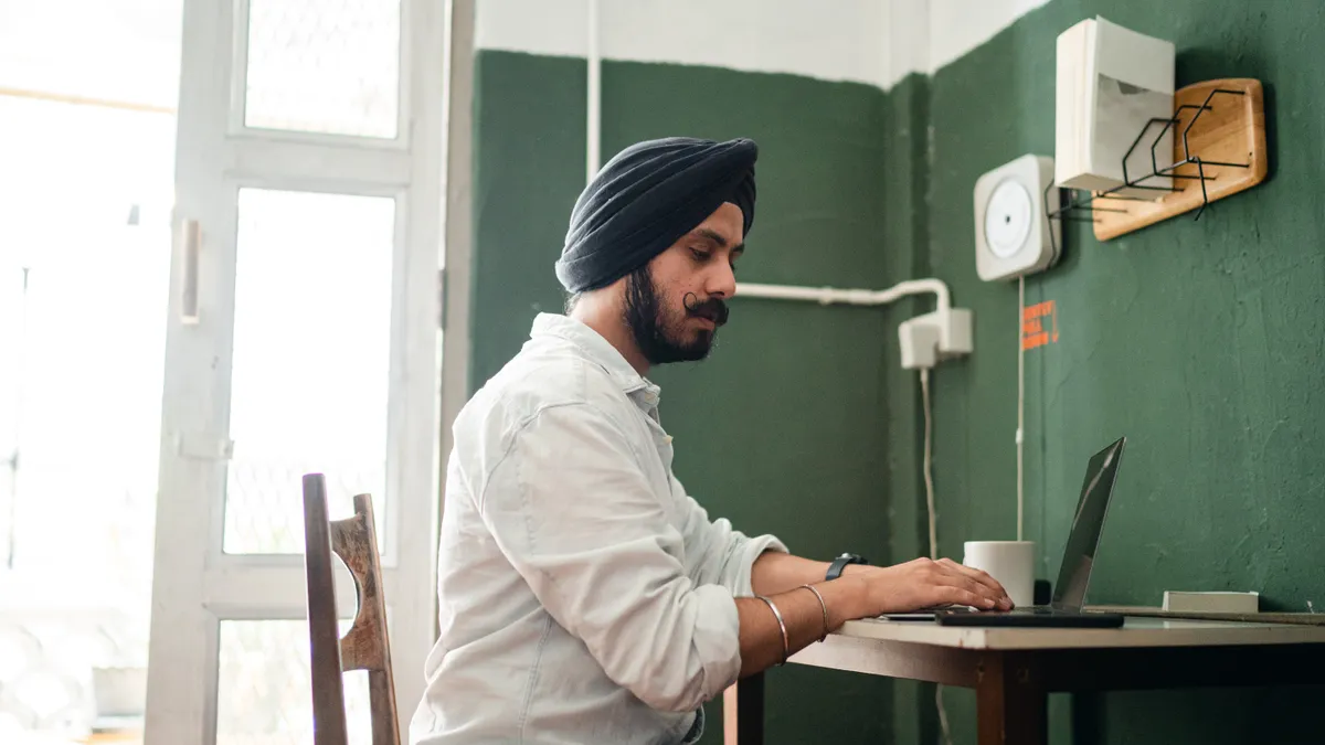 An Indian man works from home on a laptop