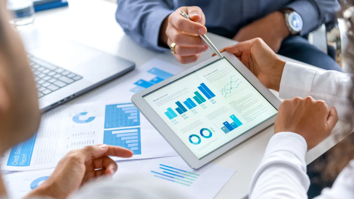 a work station with digital graphs in the center, featuring executives all around