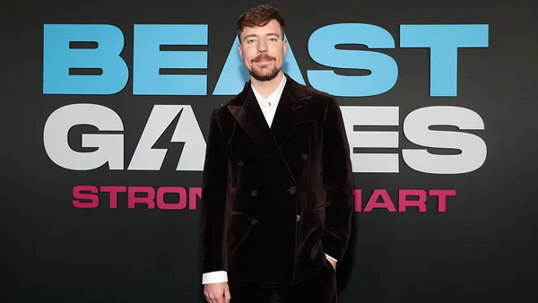 Jimmy Donaldson, aka MrBeast, is shown standing in front of text that reads "Beast Games" and "Strong / smart."