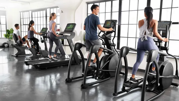 People working out on workout equipment in a gym.