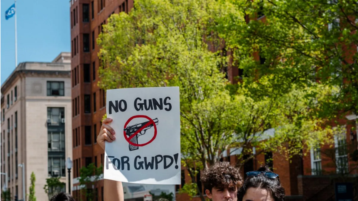 A George Washington University student holds up a protest sign.