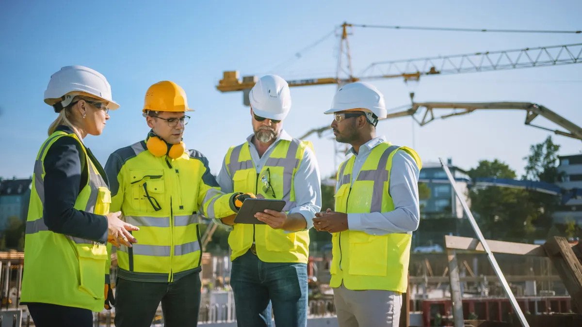 Team of Specialists Use Tablet Computer on Construction Site