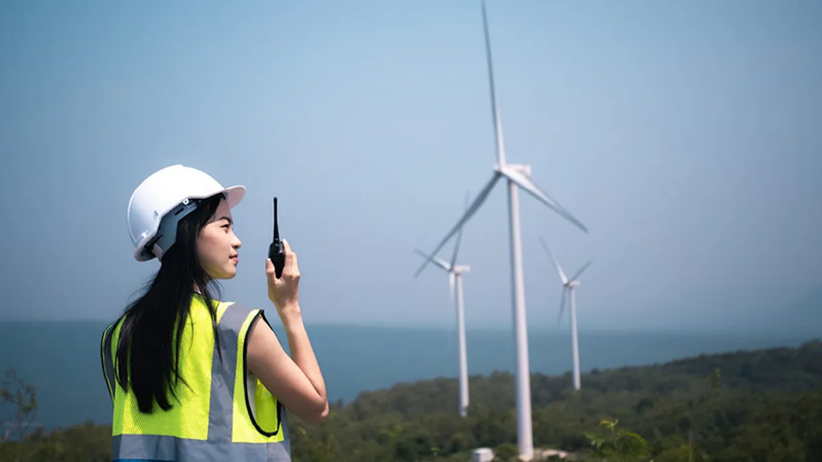 Woman worker looking at windmill