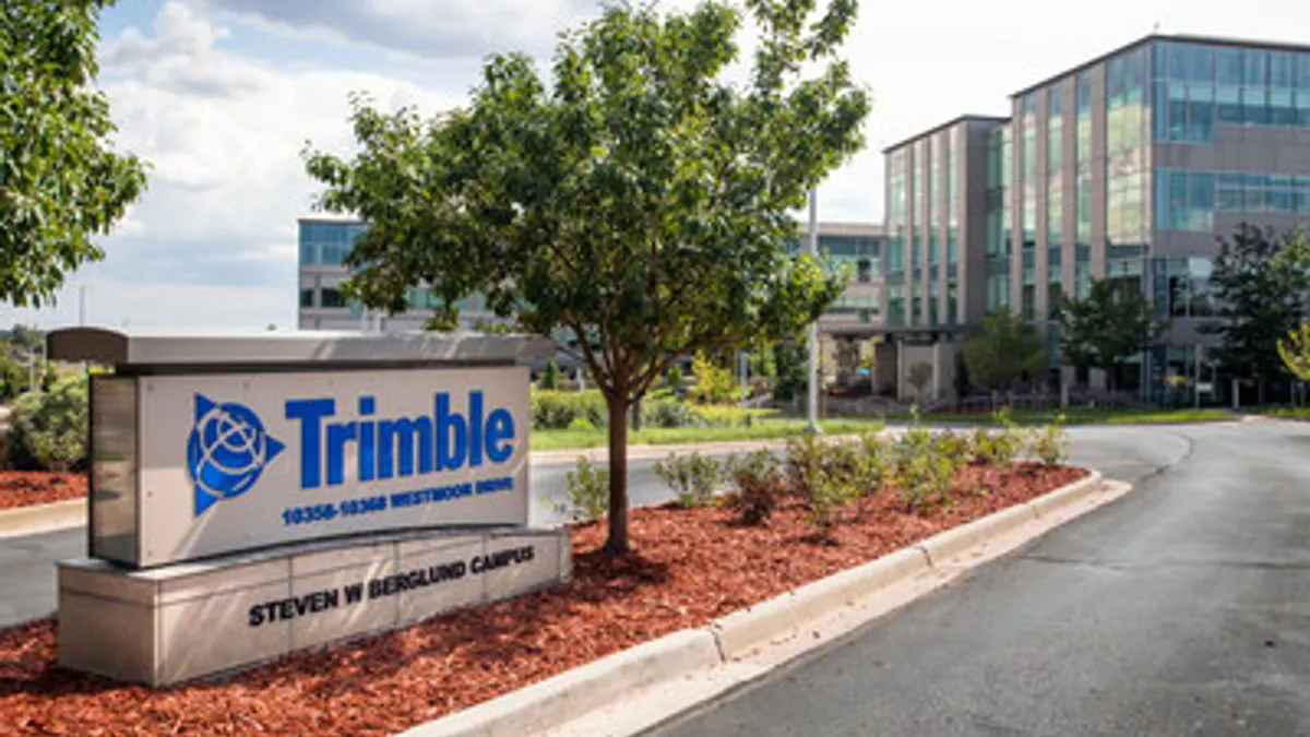 A large sign sits out front of construction technology firm Trimble's headquarters in Westminster, Colorado. The sign reads "Trimble", and a large building looms in the background.