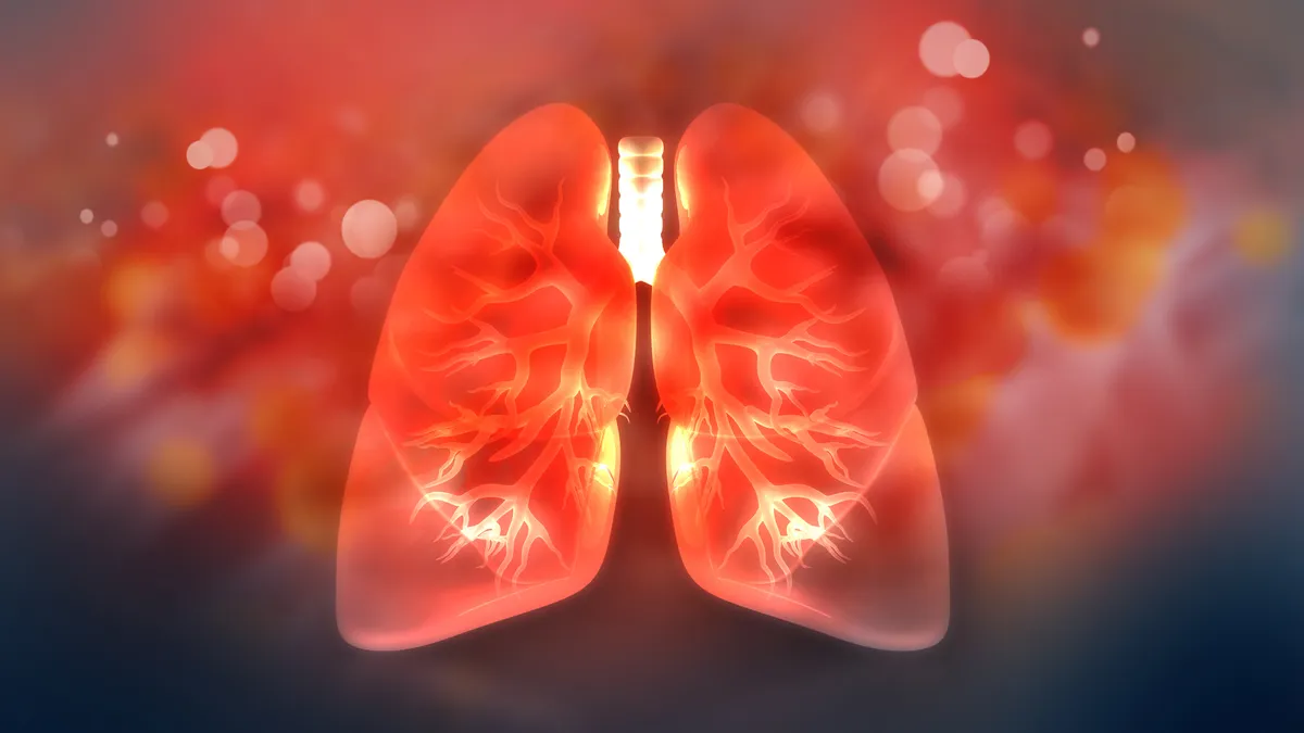 An illustration of two lungs on a scientific background colored orange.