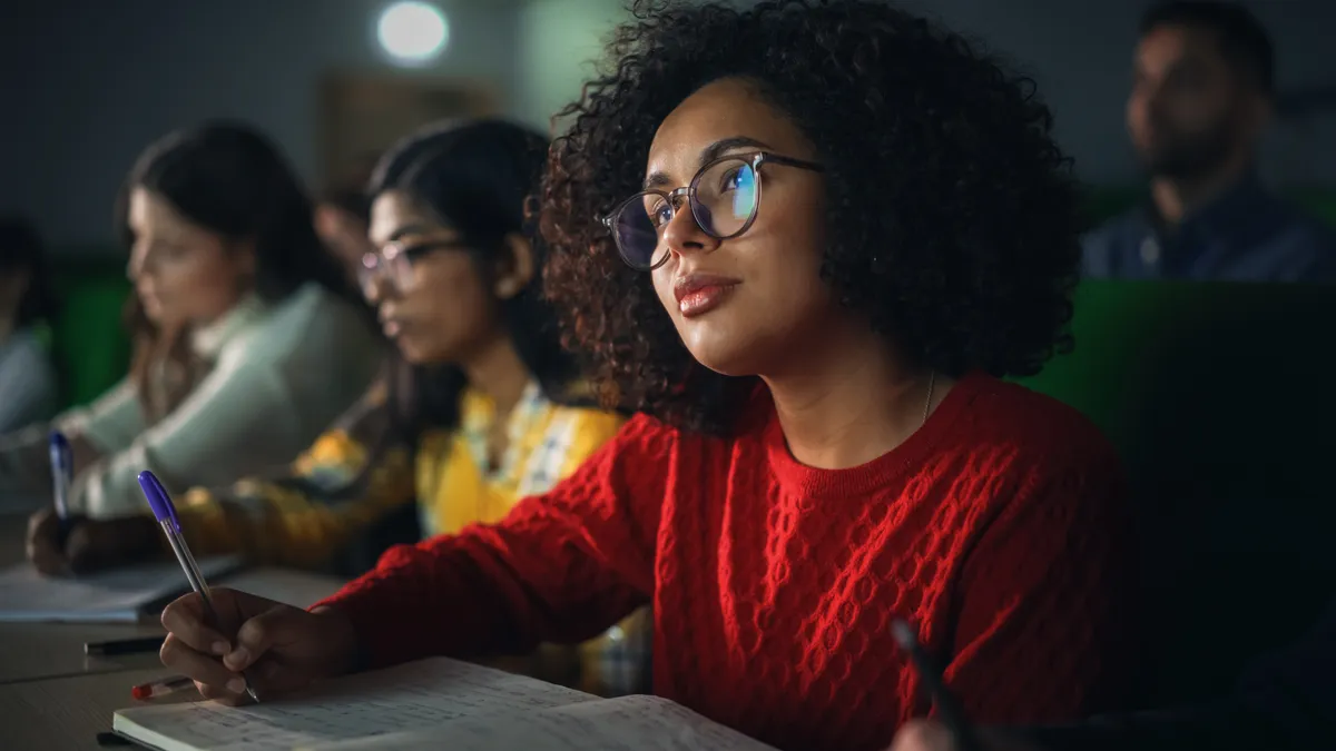 Female student studying in college with diverse colleagues