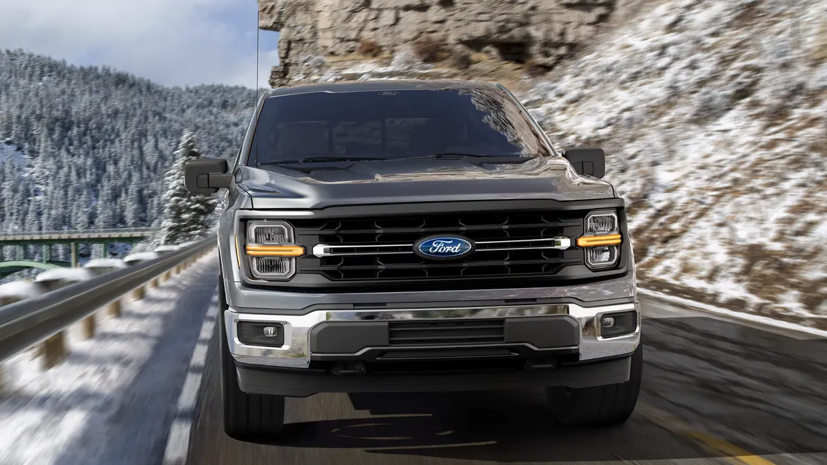 A media photo showing the front view of a 2025 Ford F-150 pickup traveling on a mountain road with snow on the ground