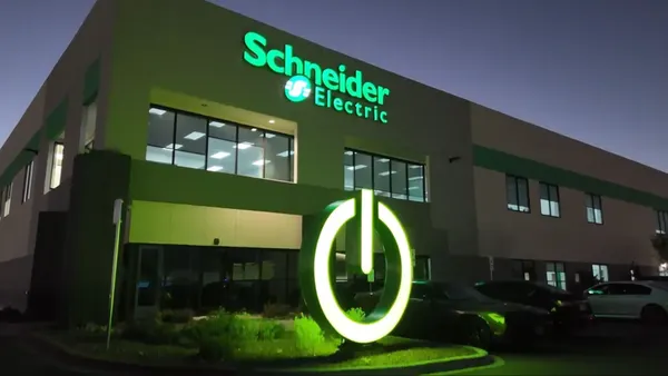 The exterior of an officie building at night with schneider electric signage