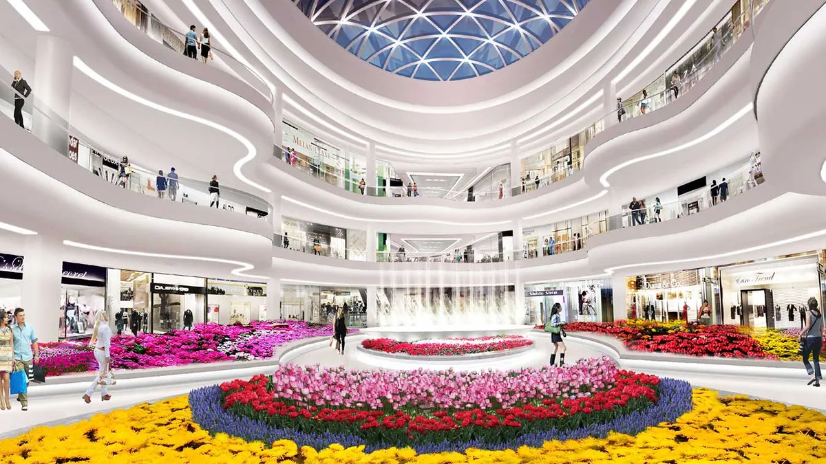 An interior shot of the massive American Dream mall, with a fountain in the middle that is surrounded by layers of pink, purple and yellow flowers.