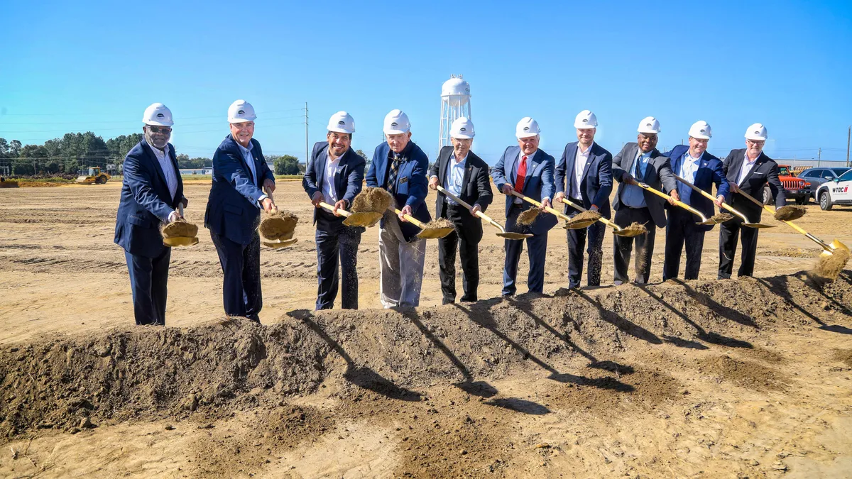 men with shovels and hard hats pose for a photo at a groundbreaking in Statesboro, Georgia.