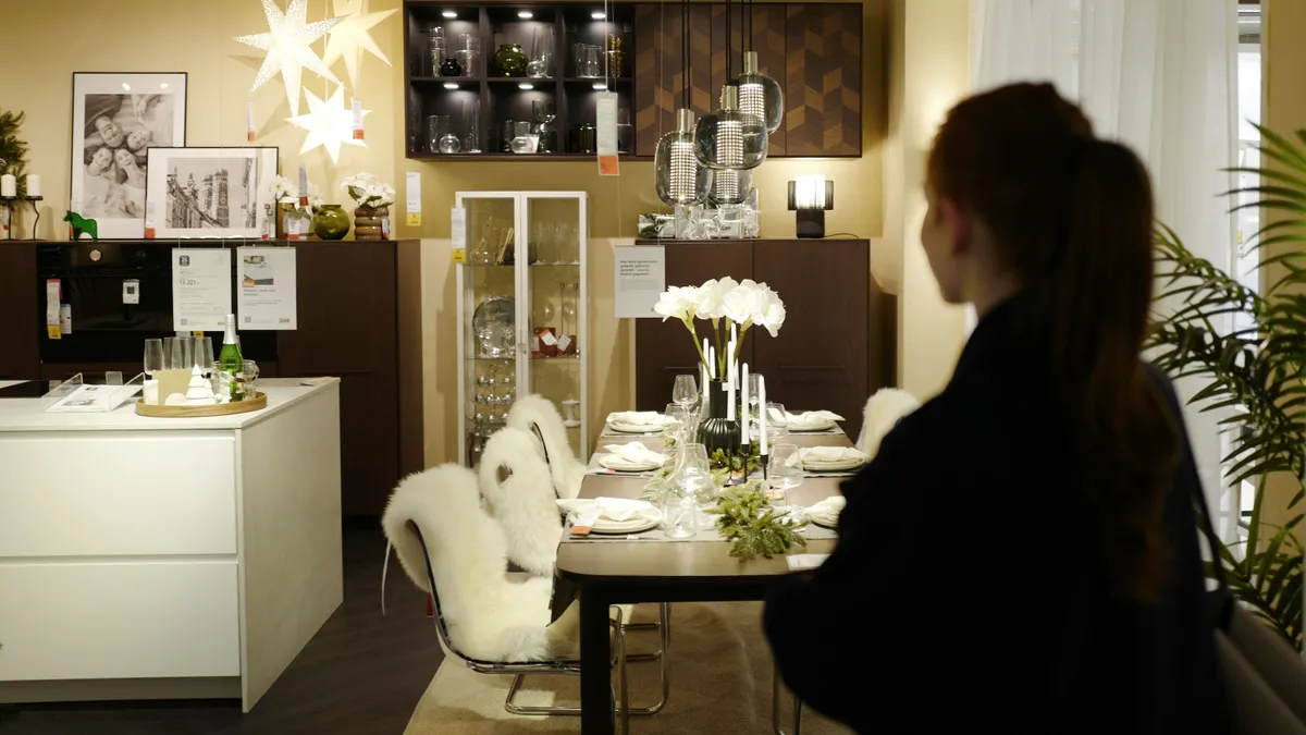 A woman looks at a dining room display in Ikea.
