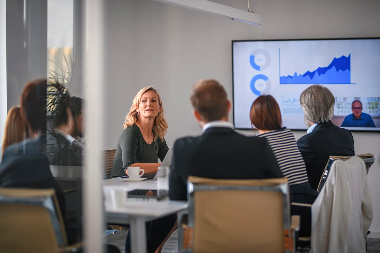 Executives are seen speaking during a meeting.