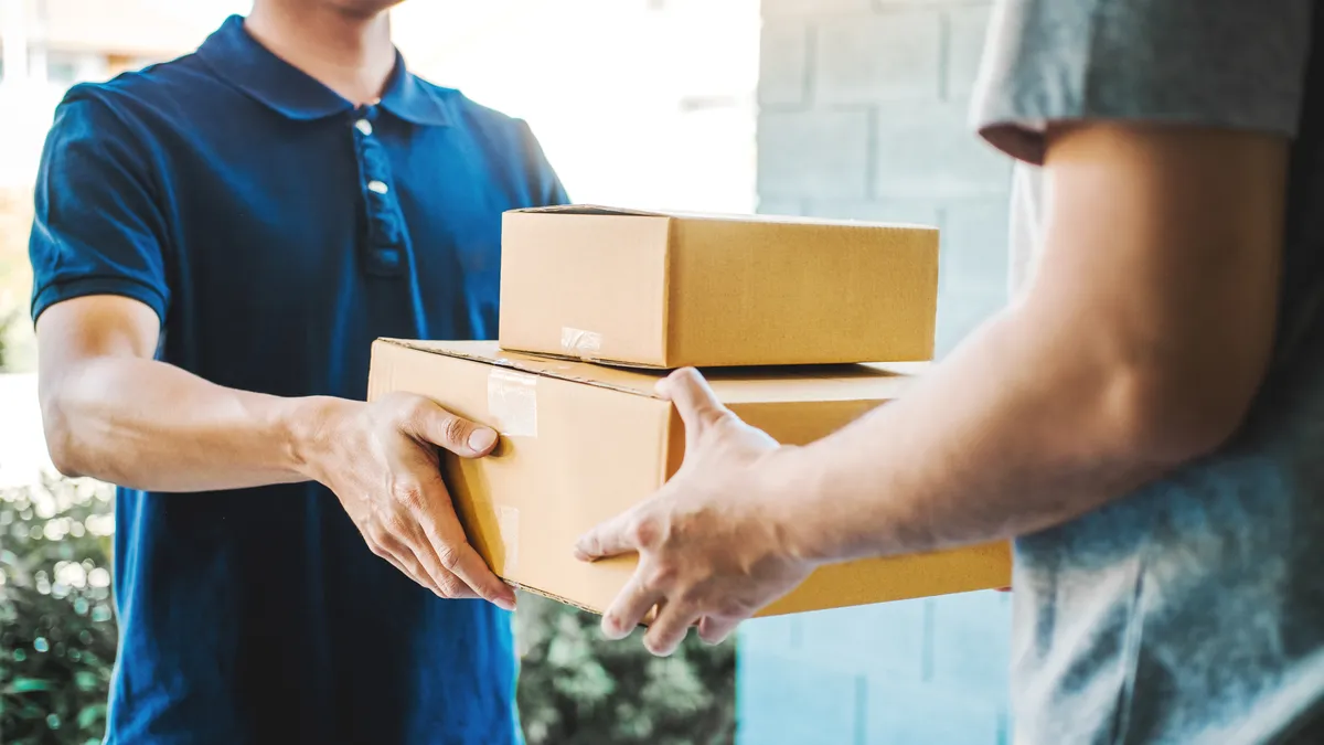 A person accepts boxes from a delivery professional.