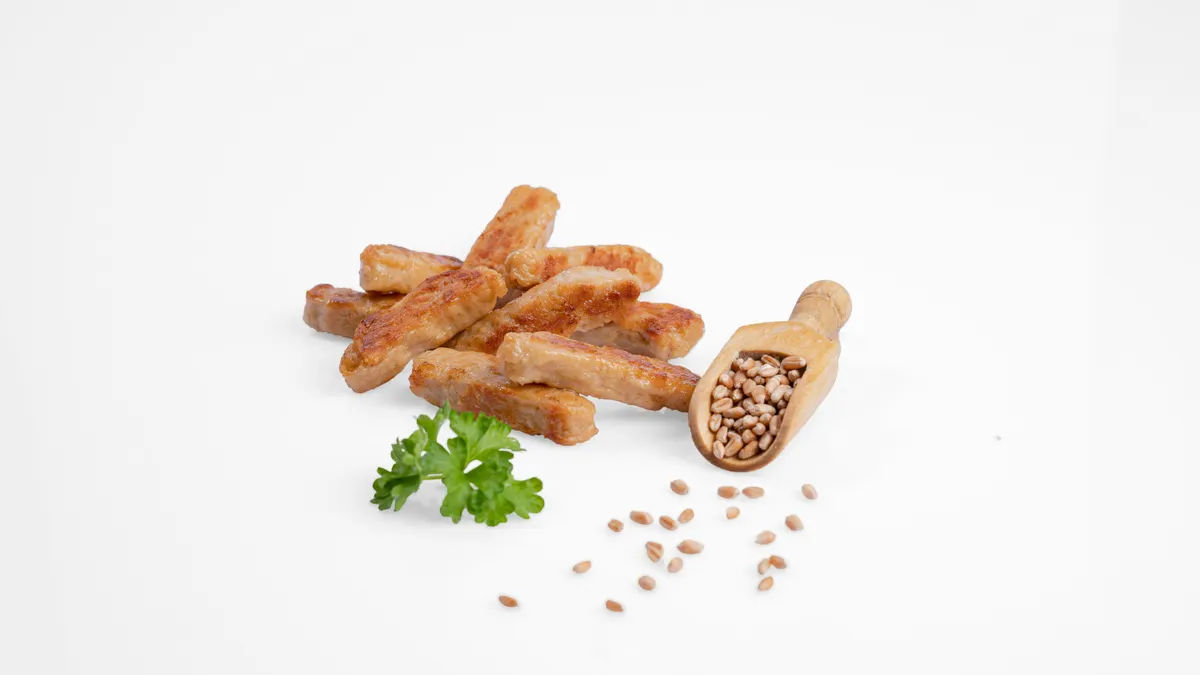 Plant-based chicken strips next to a wooden scoop of beans