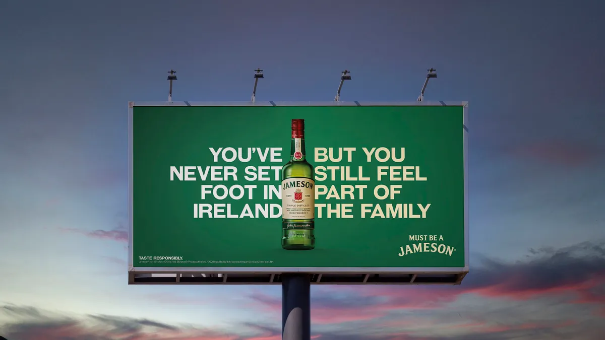 A billboard with a bottle of Jameson and a slogan.