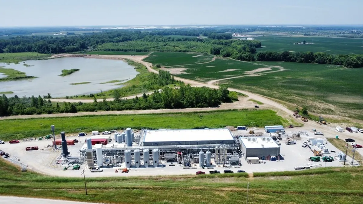 Aerial view of an industrial facility near green engineered hills