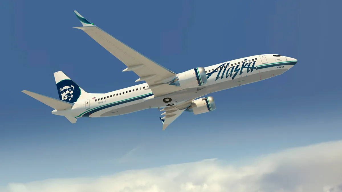 A Boeing 737 with the Alaska Airlines logo flying in the sky.