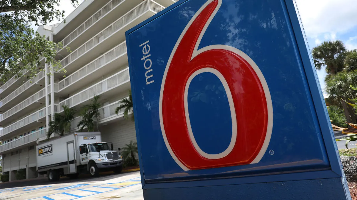 A Motel 6 sign is seen outside of a hotel building.