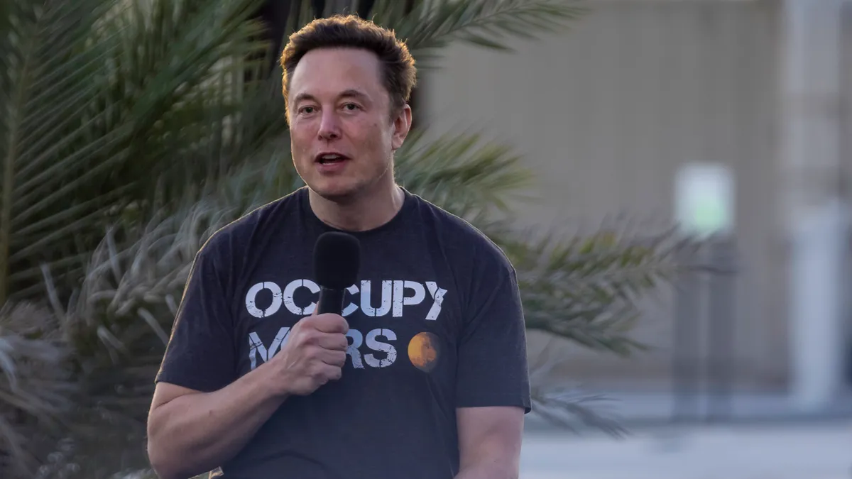 SpaceX founder Elon Musk speaks to a crowd in Texas; he is wearing an "OCCUPY MARS" shirt