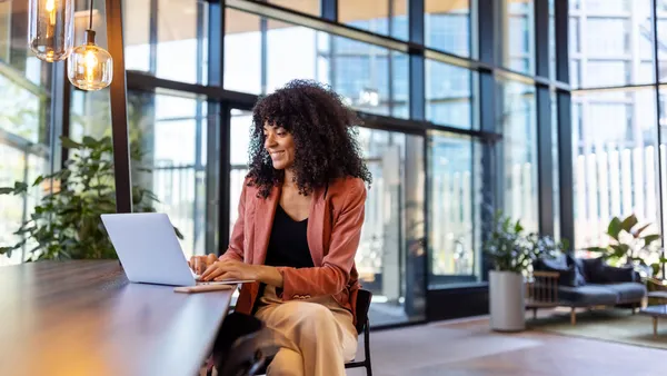 Happy young woman working on laptop
