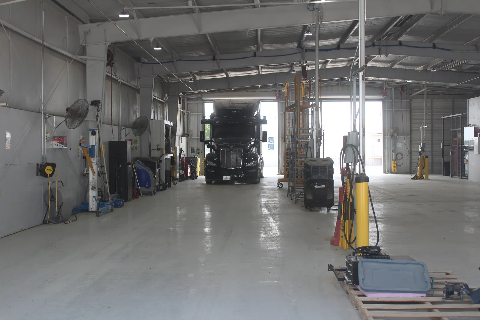 A blue Aurora autonomous truck inside a maintenance building.