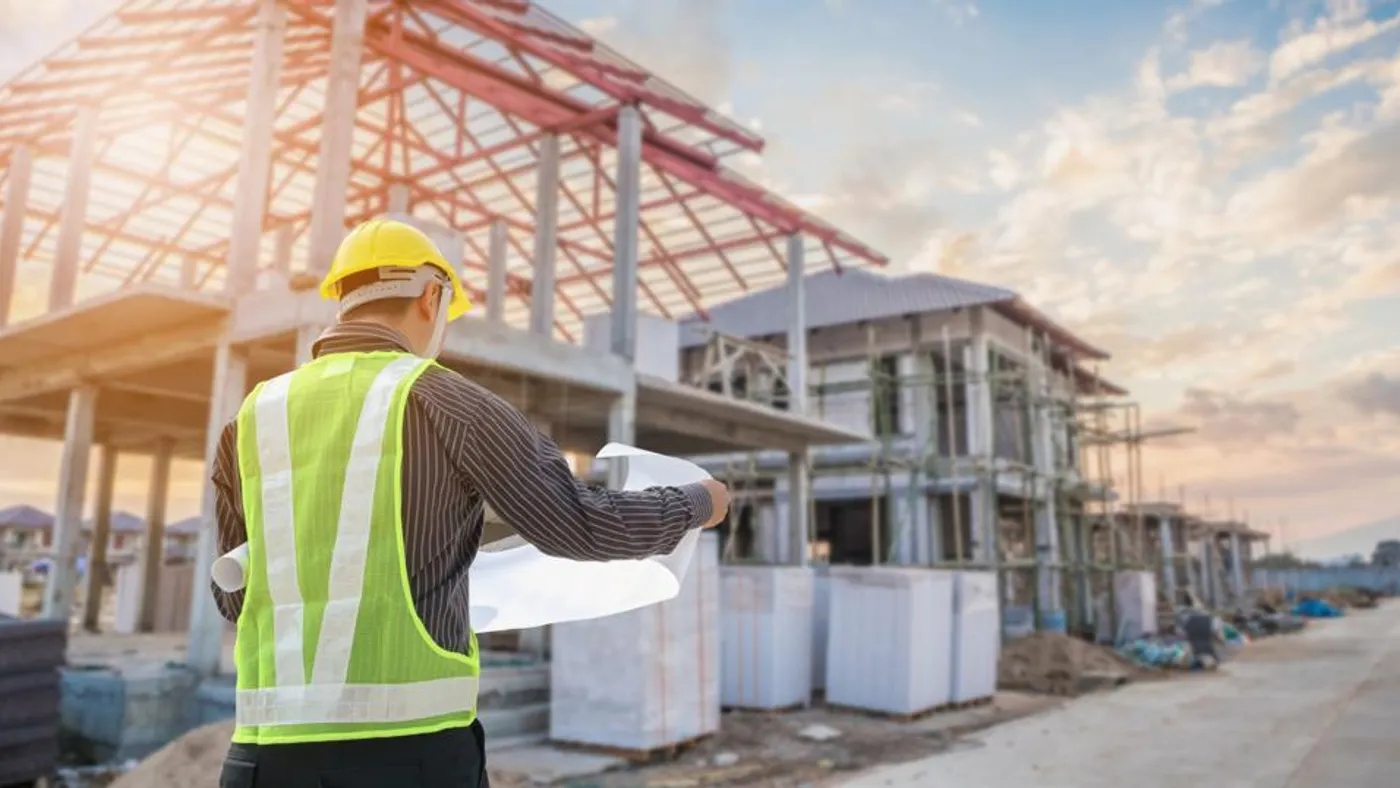 Person in protective gear in front of a construction site