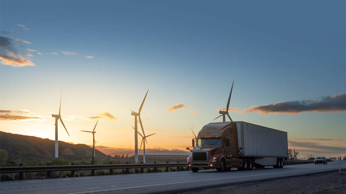 Truck driving down the road during sunset