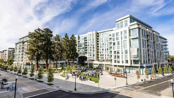 Picture of white, new mid-rise apartment building on street corner