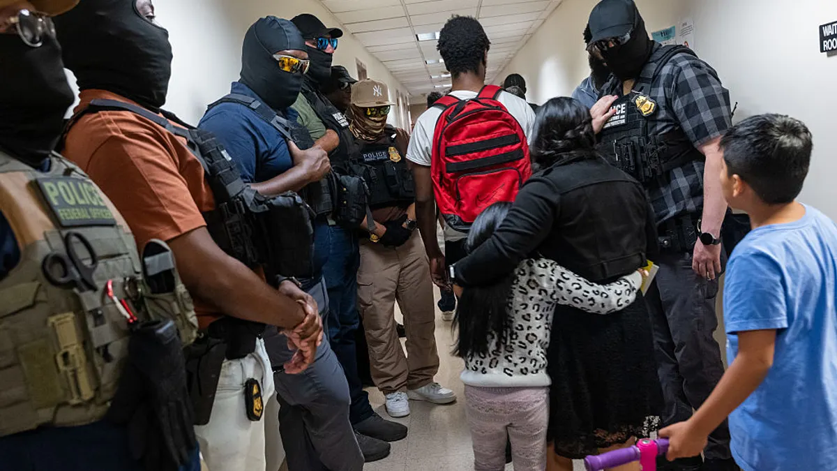 Immigration enforcement agents, including those from ICE, line the hallways outside immigration court in New York City