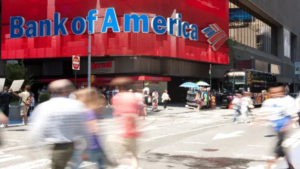 People and tourist walking by the colorful electronic sign of Bank of America in Times Square.