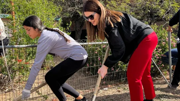 Two people using shovels to dig holes.