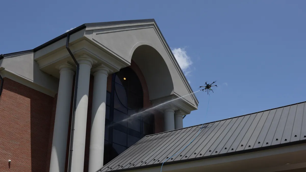 An aerial drone deployed by Window Hero is seen near a commercial building