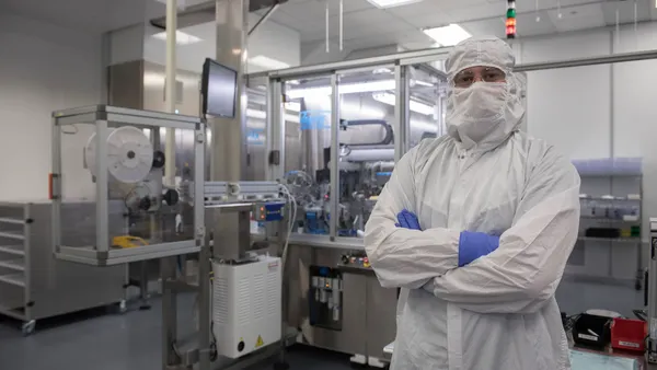 Woker in Pharmaceutical lab with equiment behind